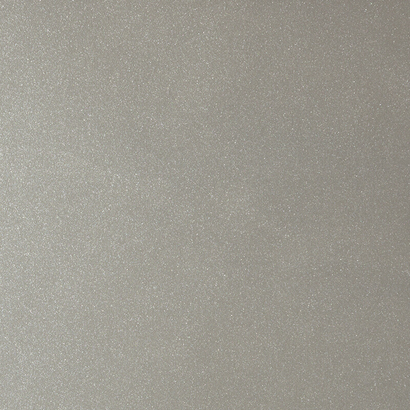 A close-up of a smooth, light gray surface with a subtle, shimmery texture. The surface appears even and slightly reflective, with fine specks creating a gentle sparkle.